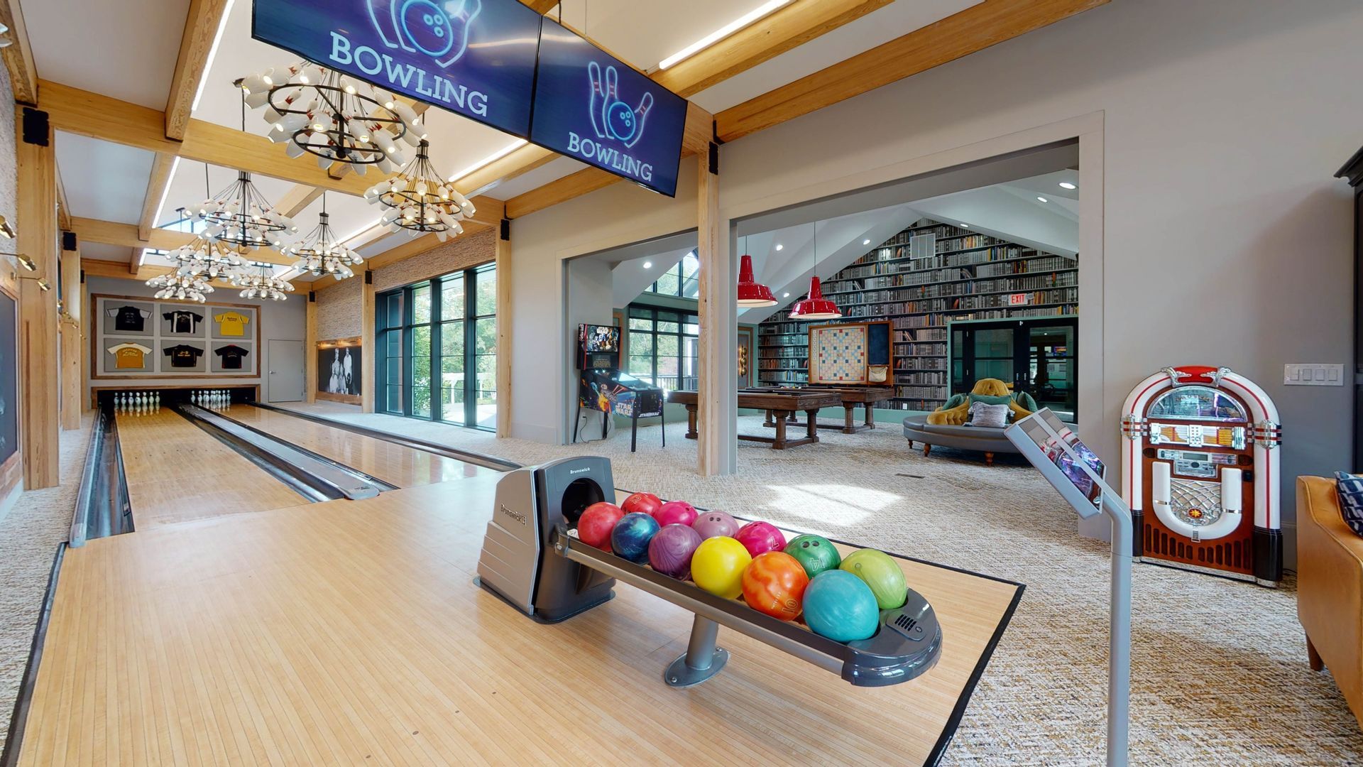 Indoor bowling alley with wood lanes, colorful bowling balls, and jukebox.