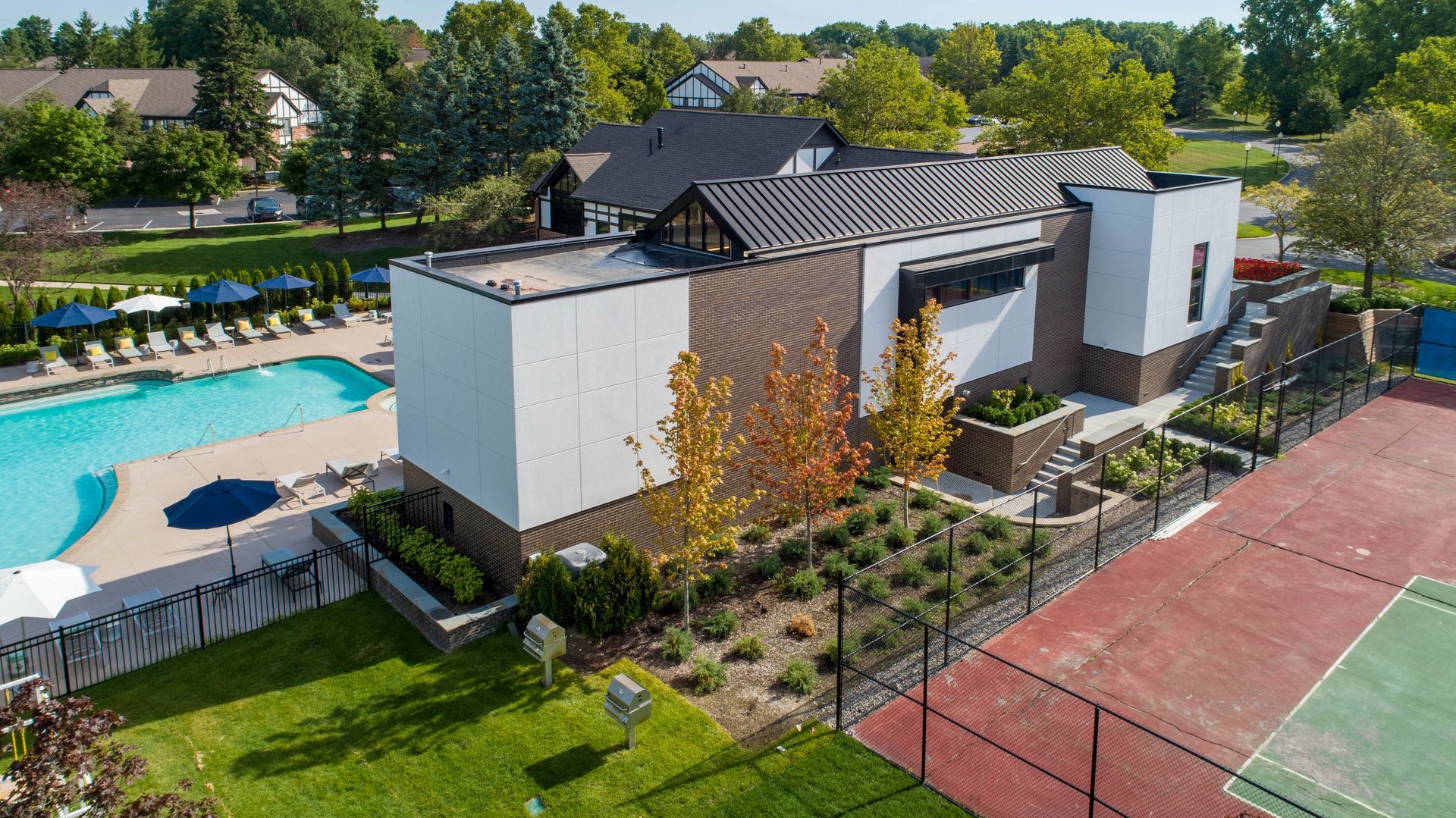 An aerial view of a tennis court and a swimming pool