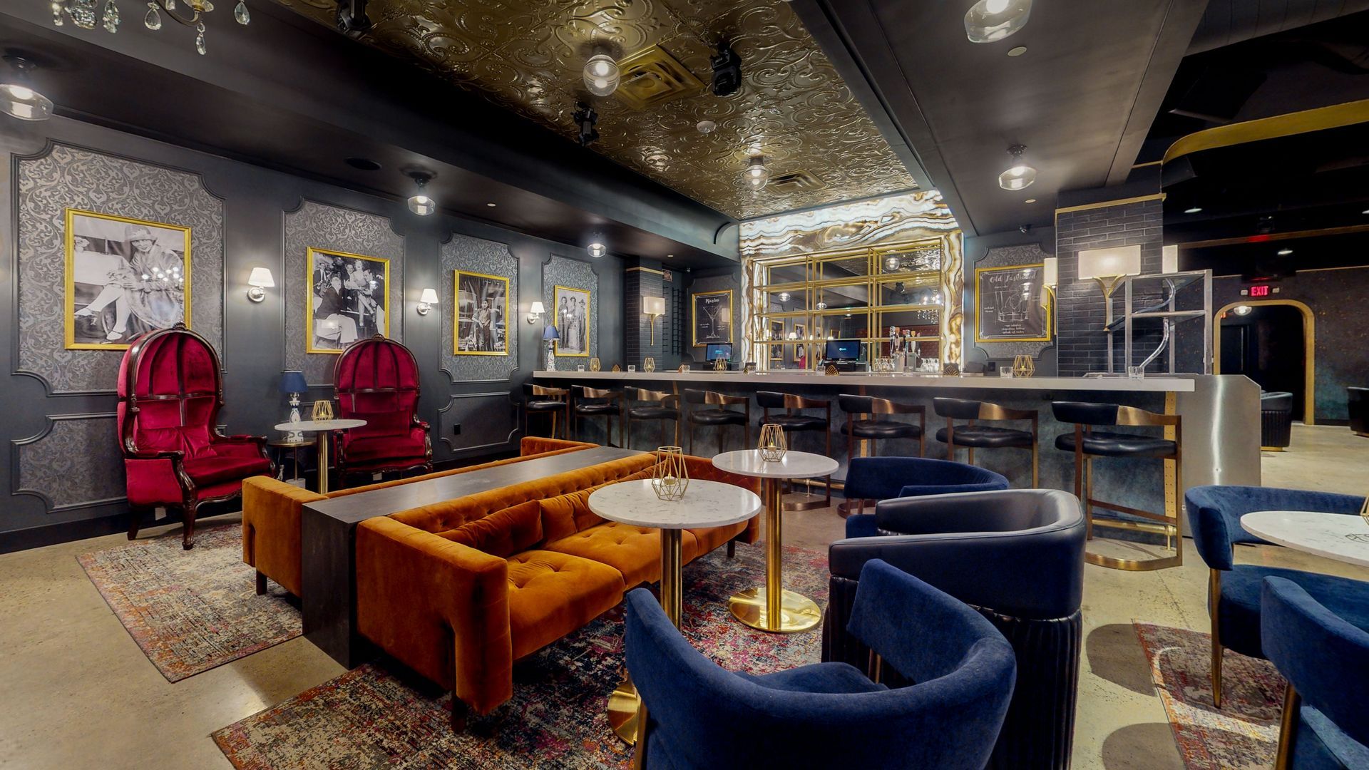 Upscale bar interior with velvet seating, dark walls, and gold accents.