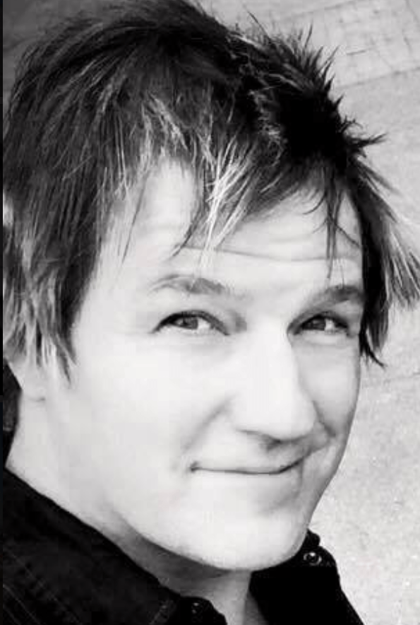 A black and white photo of a young man smiling.