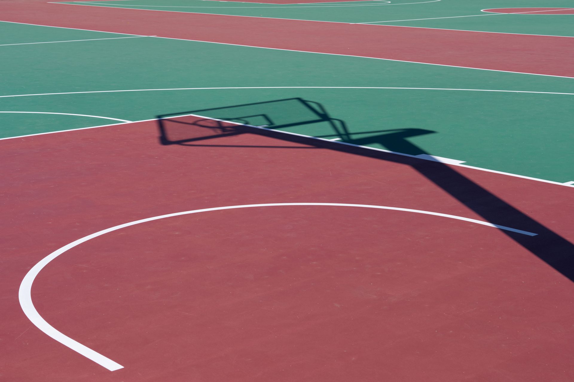 A basketball hoop on a red and green court