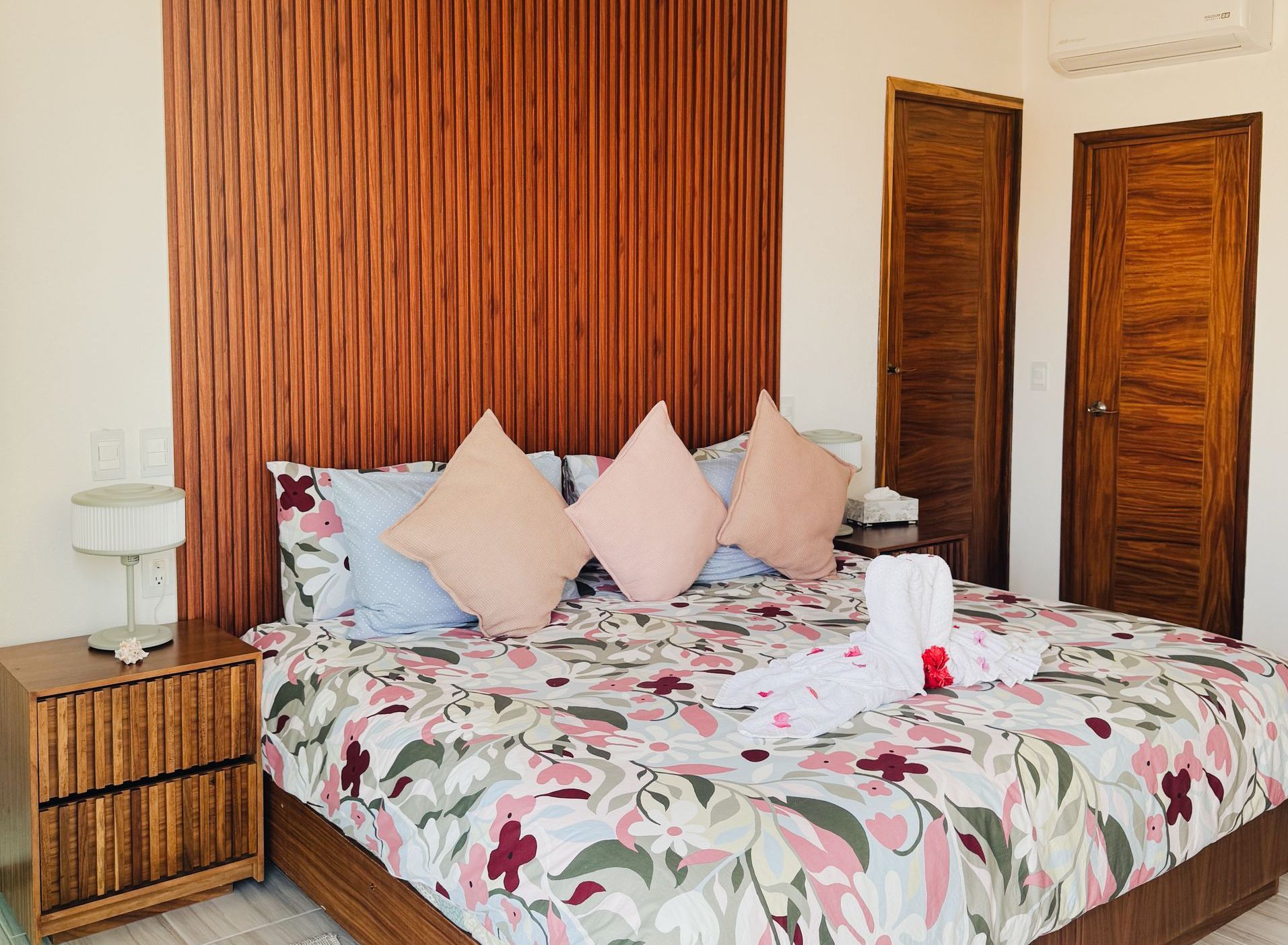 Un dormitorio con una cama king size y una cabecera de madera.