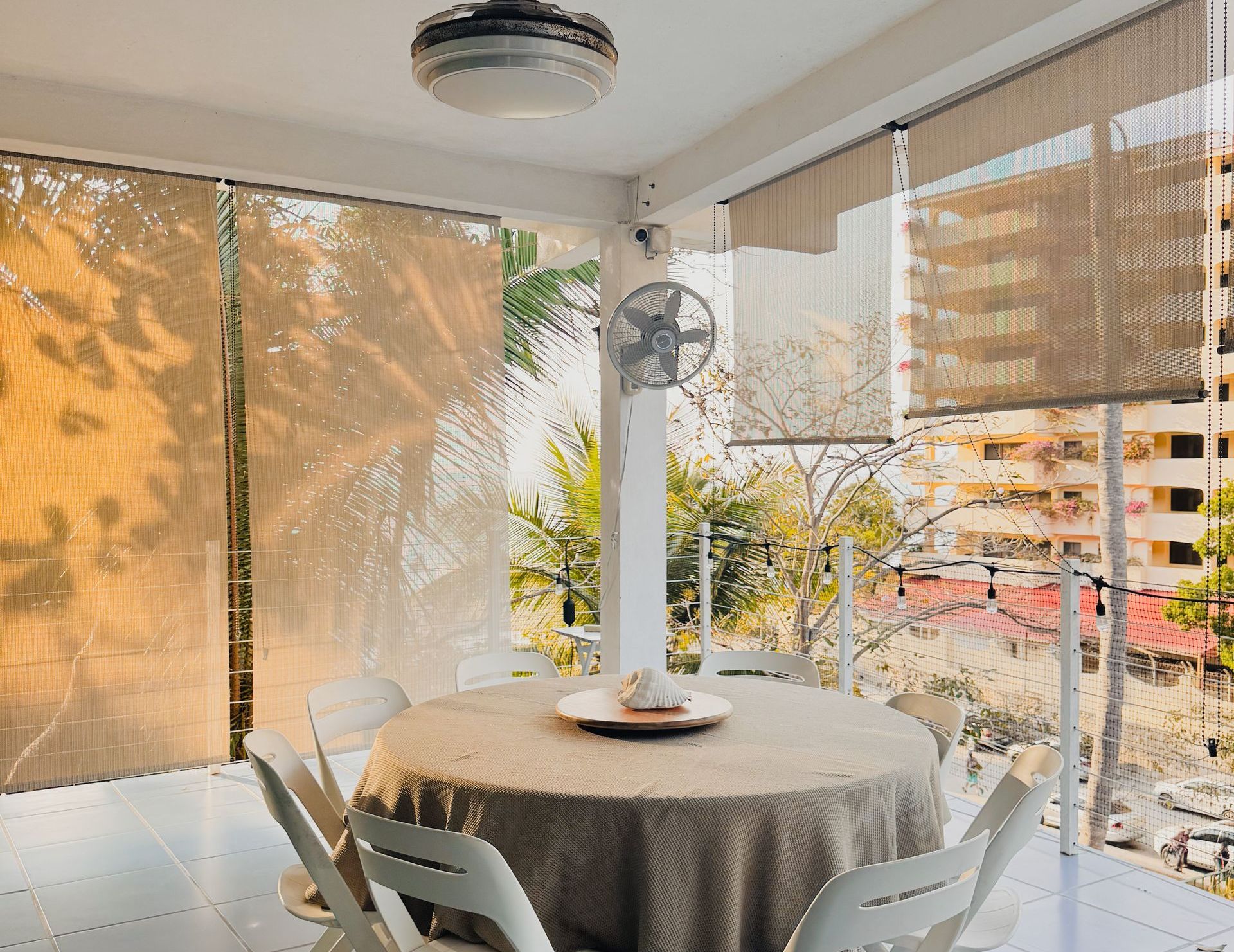 Un comedor con mesa y sillas y un ventilador.