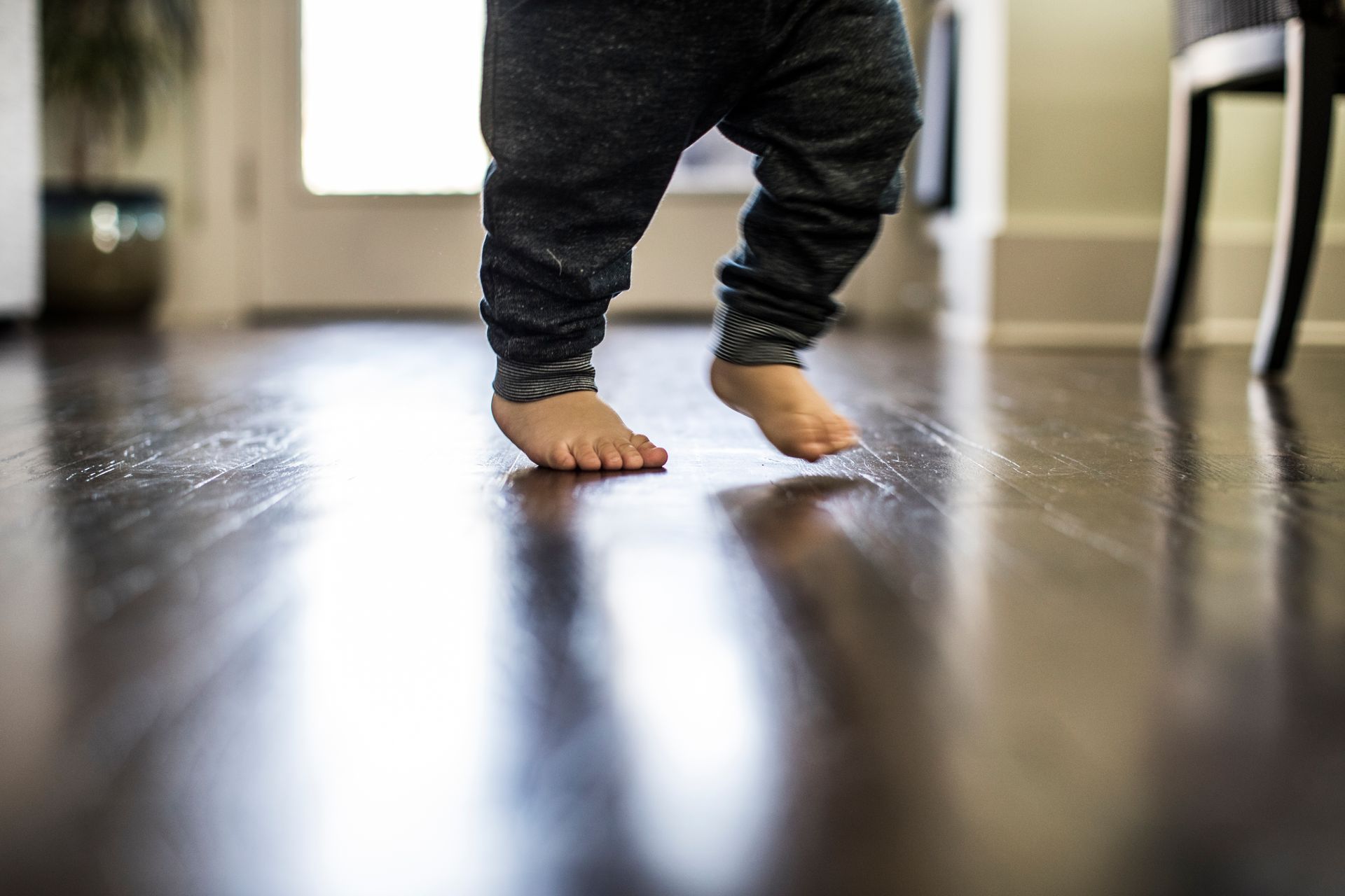 parquet legno naturale scuso con bambino che cammina scalzo