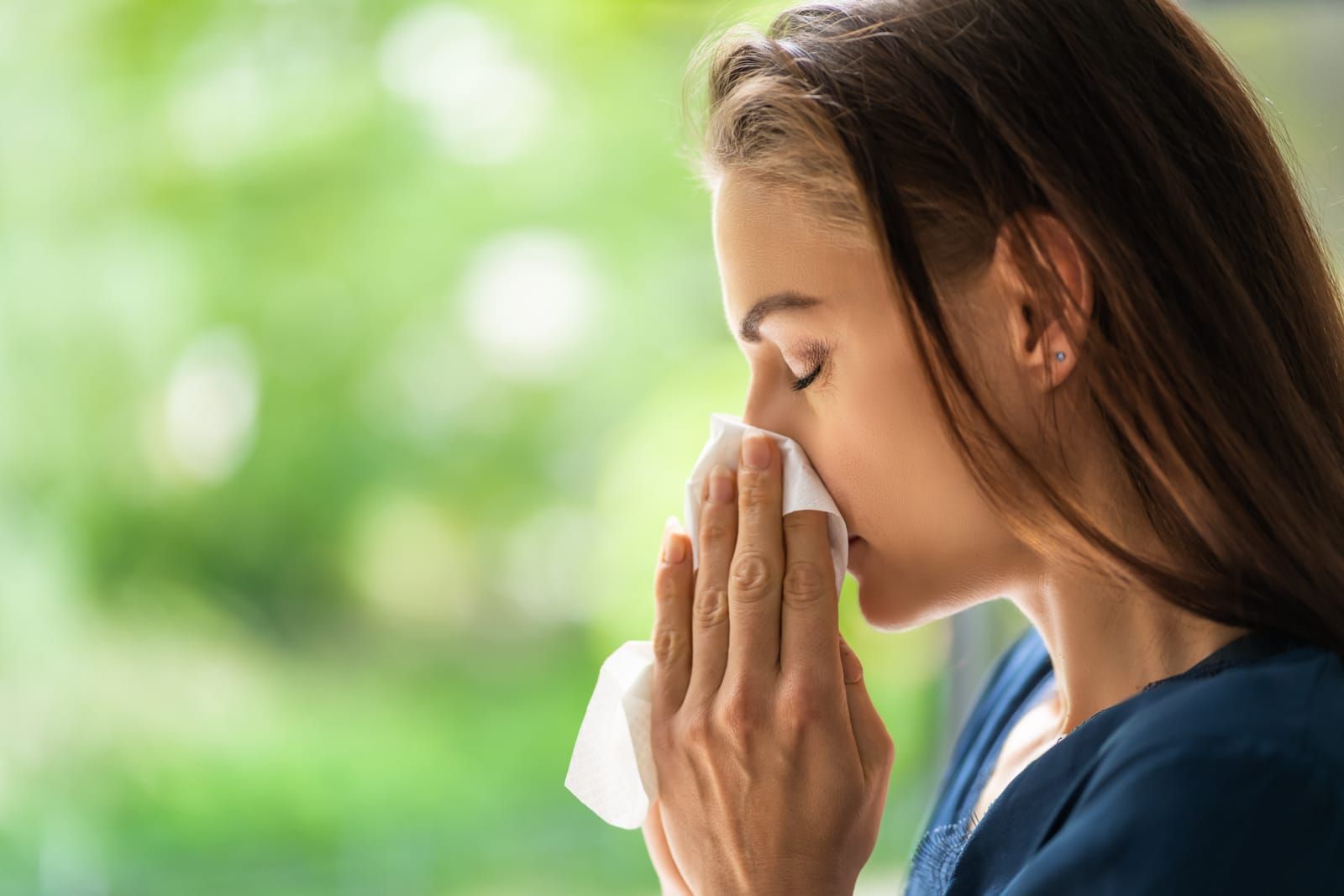A person sneezing due to allergies