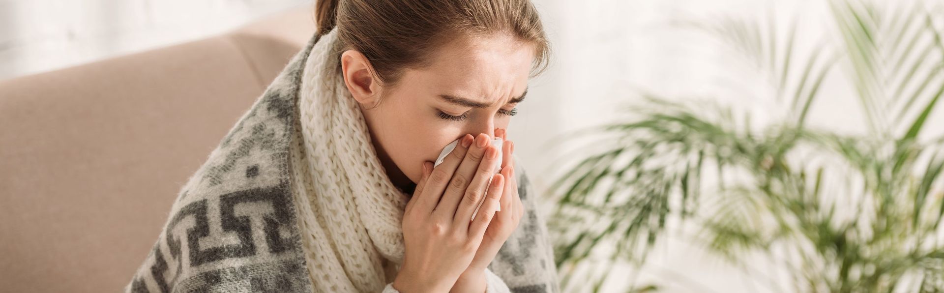 Senior man suffering from cold or allergy blows nose snot into a  napkin at home