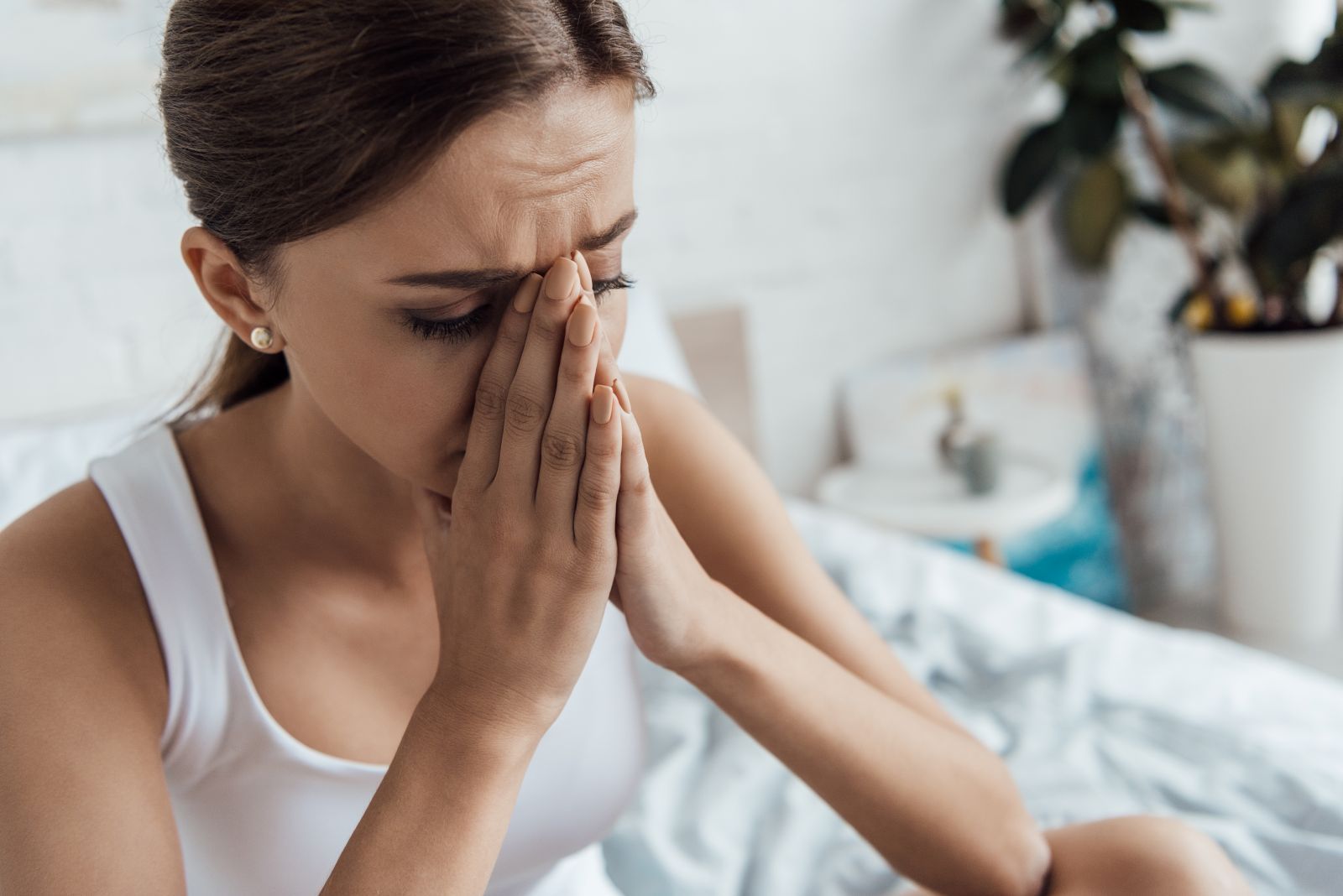 a woman struggling with sinusitis holding her nose