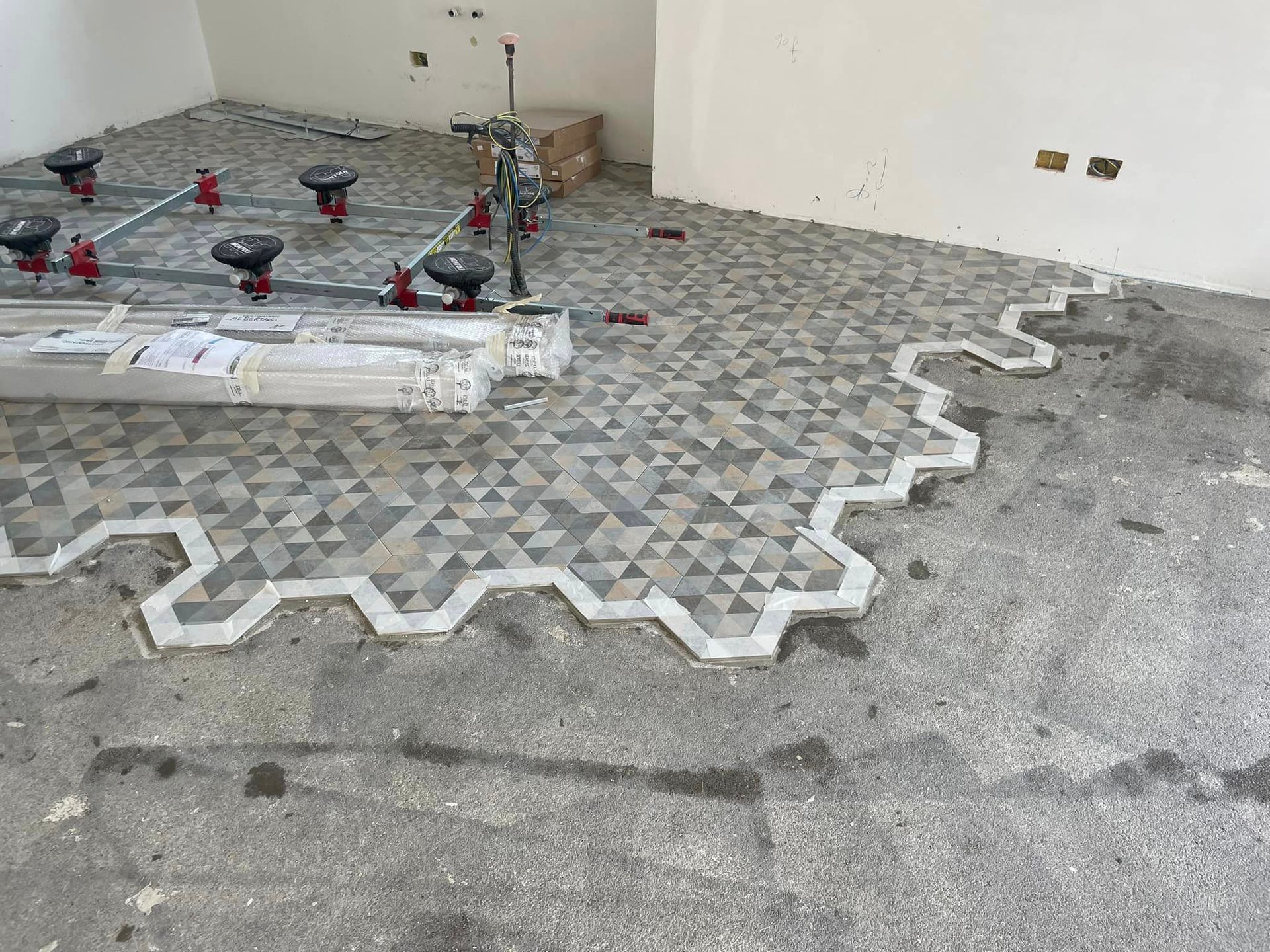 Posa di pavimentazione decorata a lato del muro di un edificio in un cantiere.