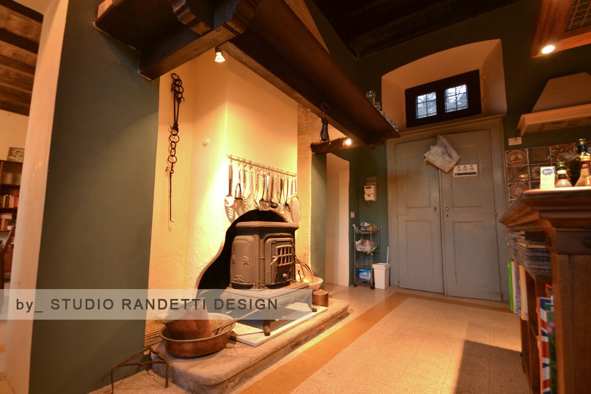 Accogliente soggiorno rustico con camino, travi in ​​legno e una porta grigia sul retro.