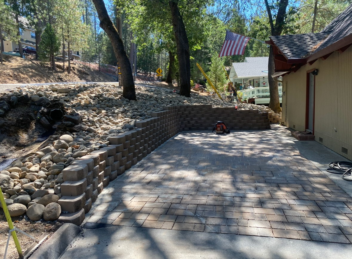 A brick driveway is being built in front of a house.