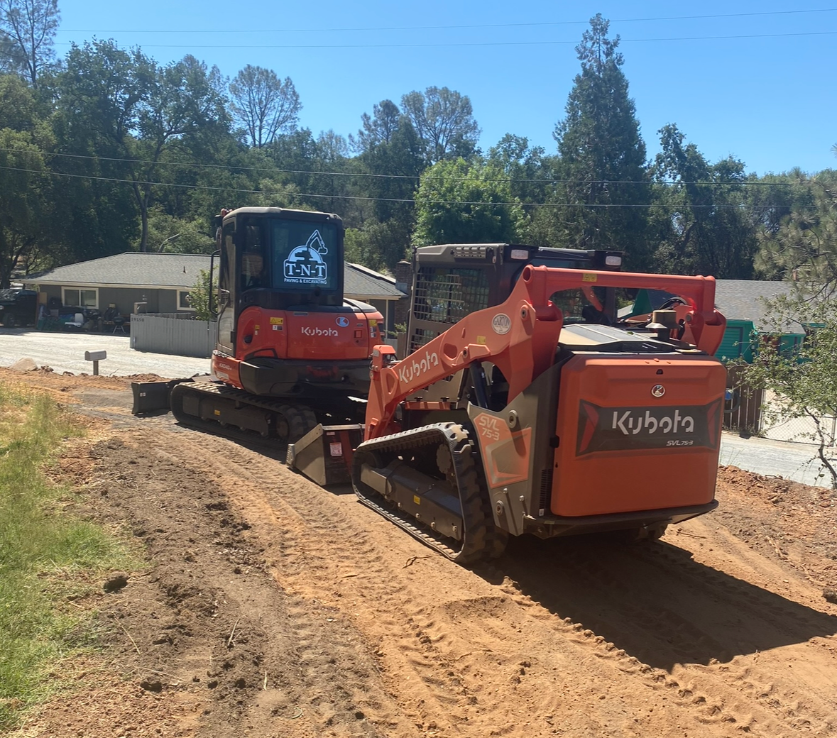 A kubota bulldozer is driving down a dirt road