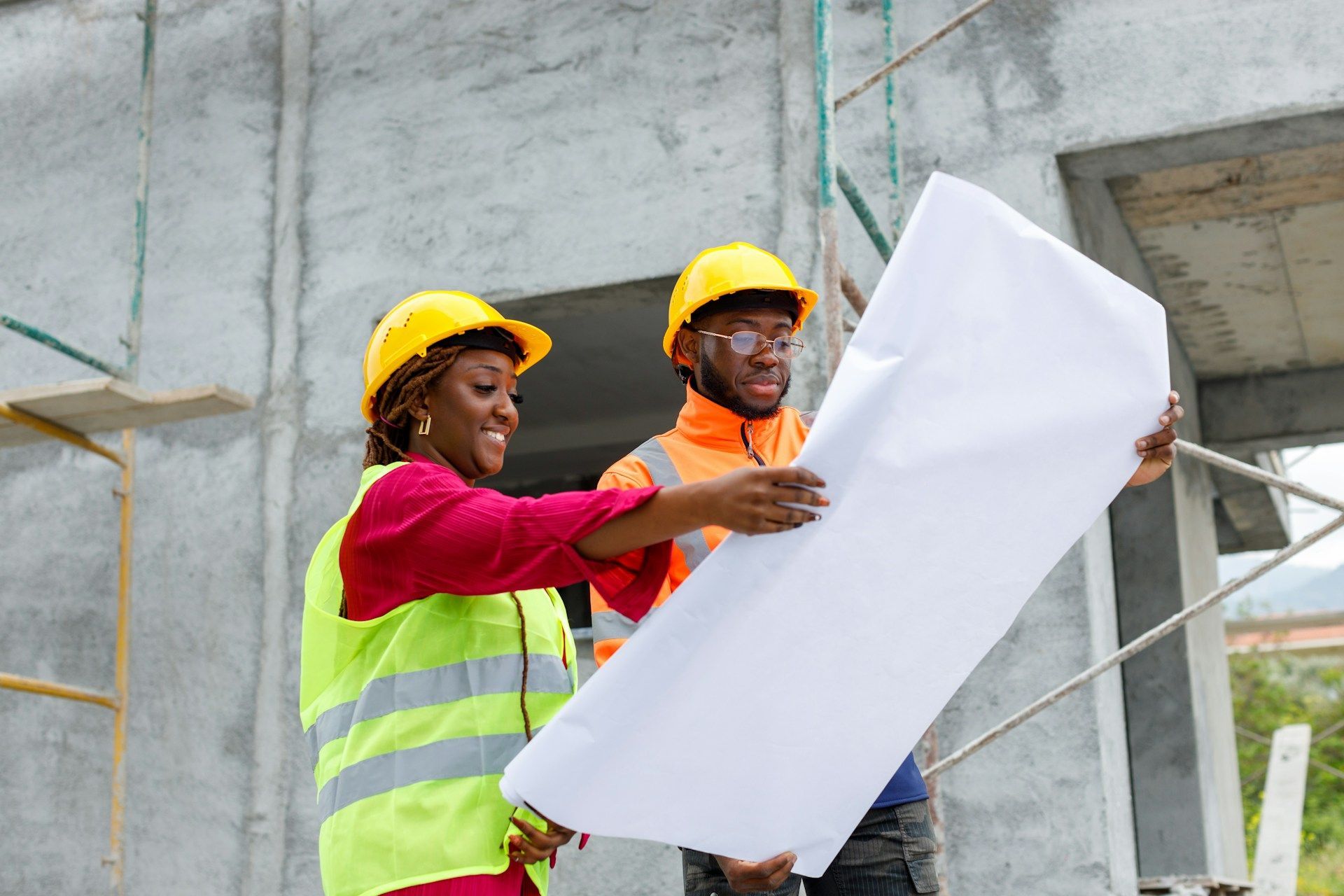 Man and woman looking at paperwork in a warehouse setting, surrounded by boxes on shelves.