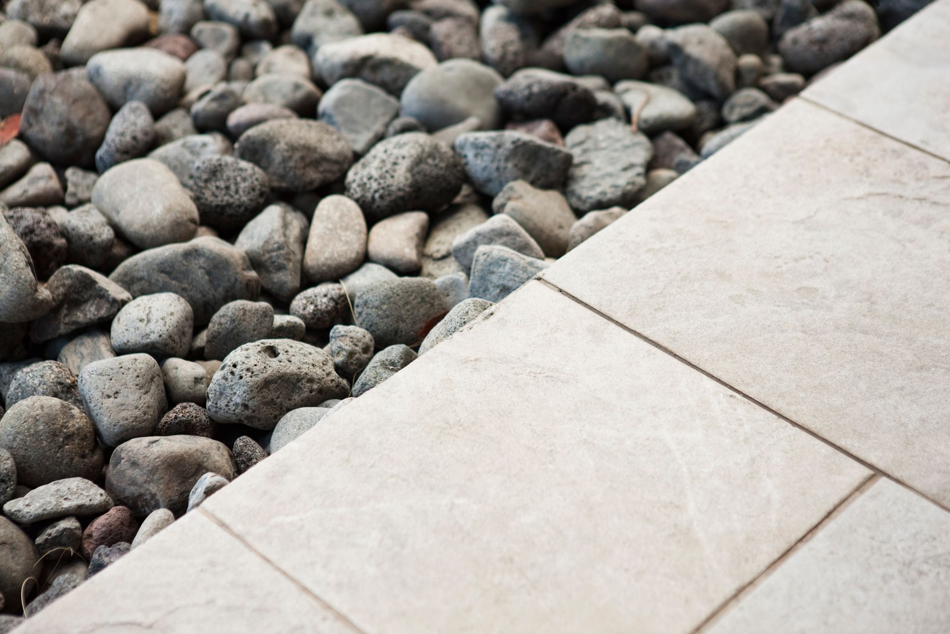 Gravel along edge of tiled patio