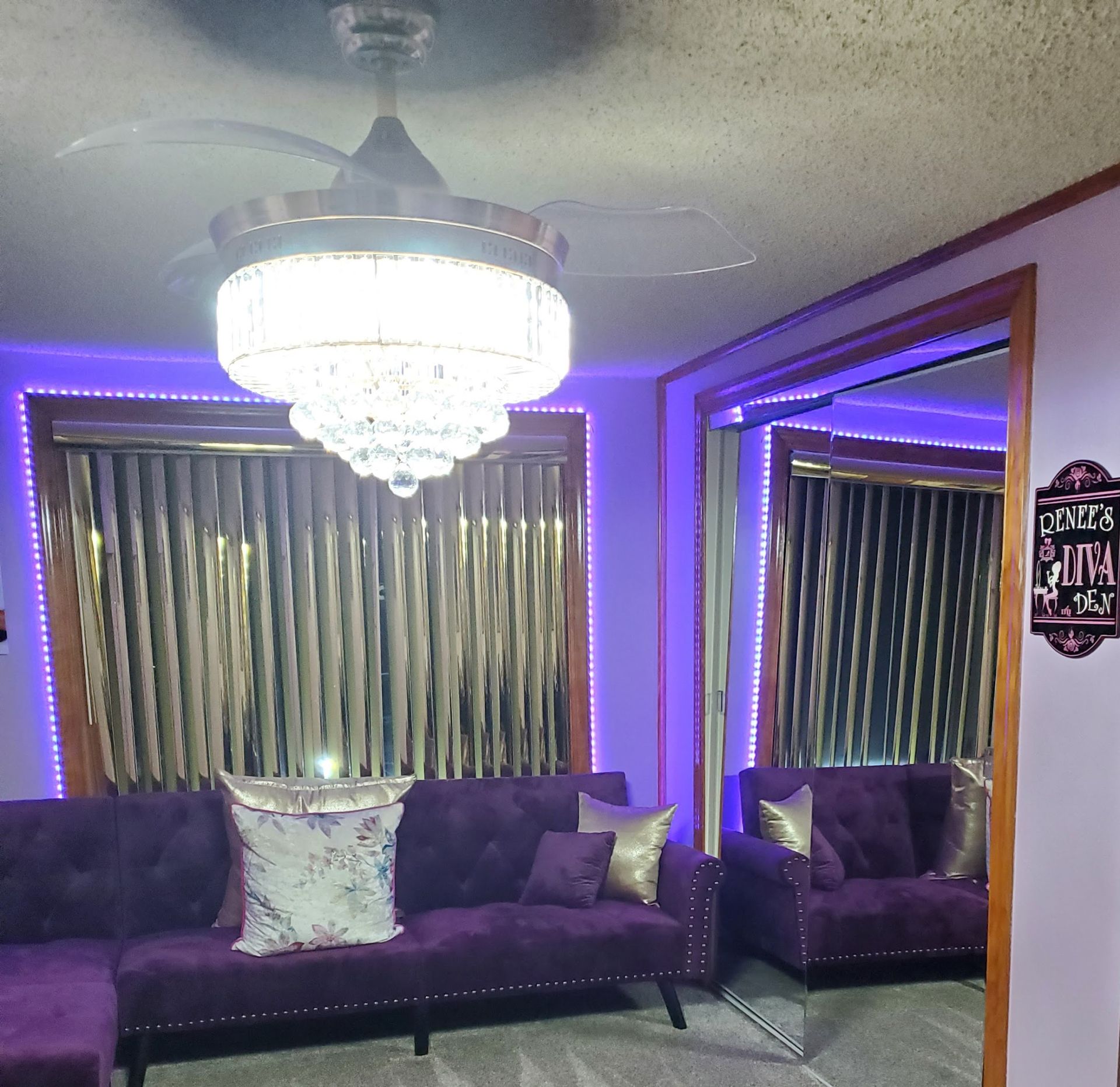 A living room with a purple couch and a ceiling fan