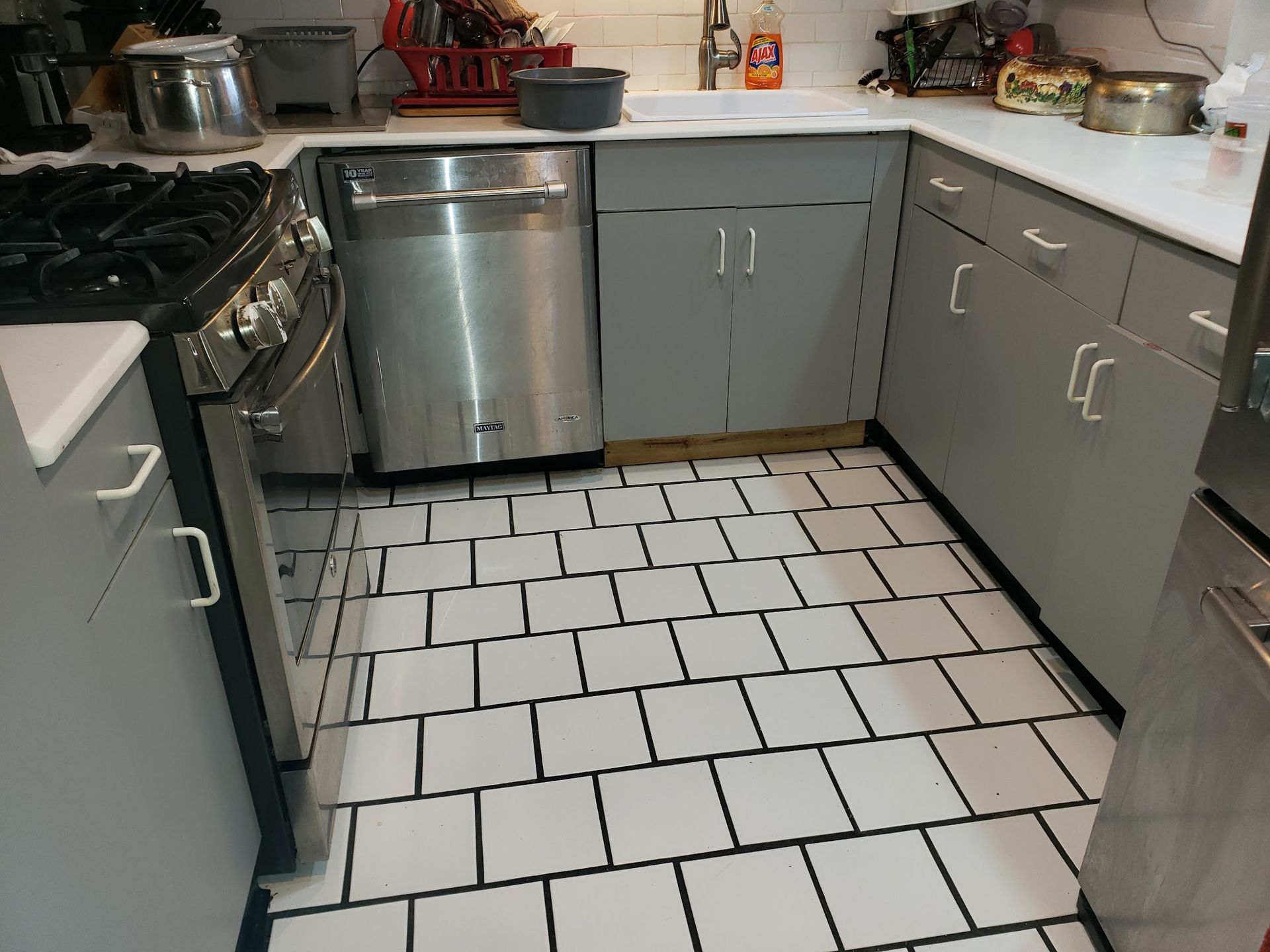A kitchen with stainless steel appliances and white tile floors