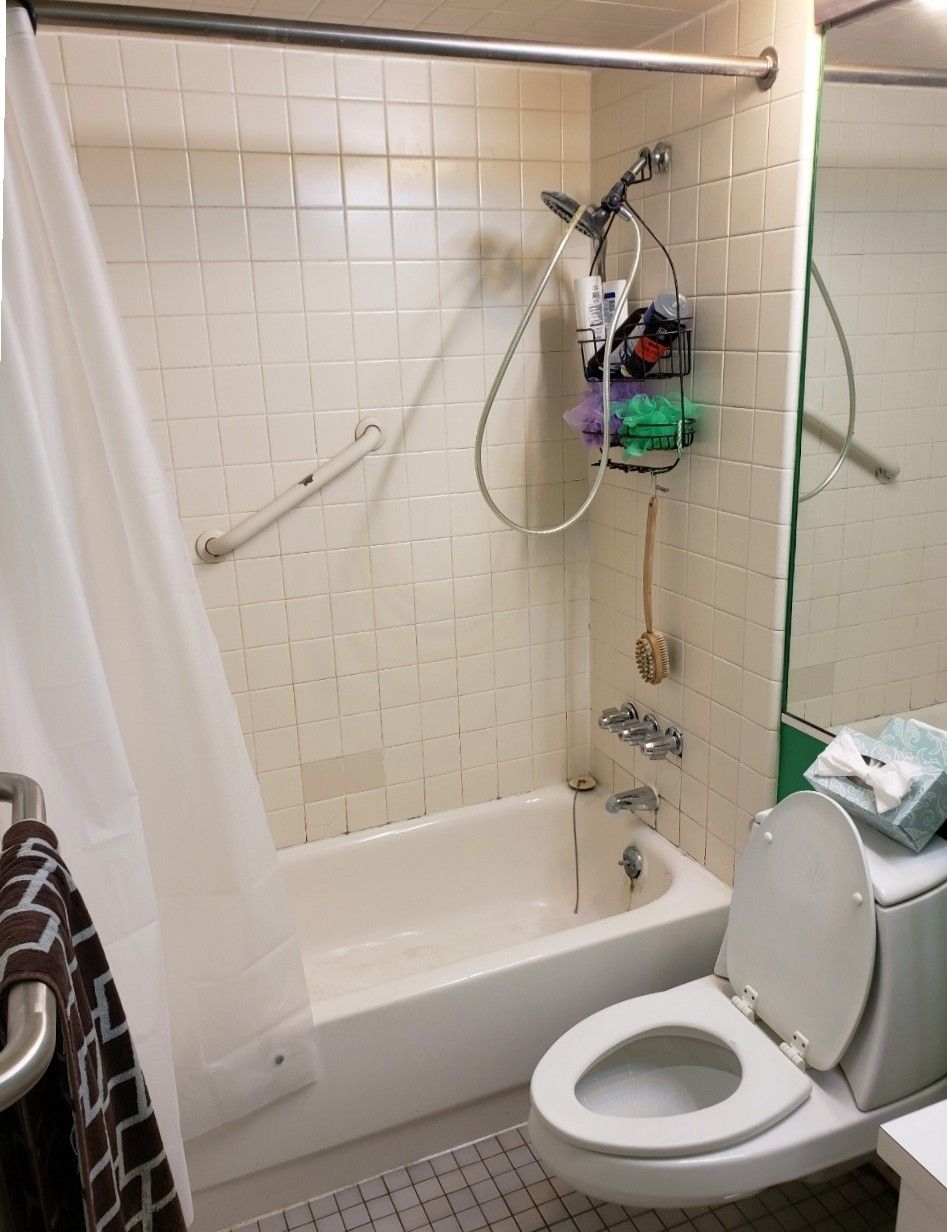 A bathroom with a toilet a tub and a shower