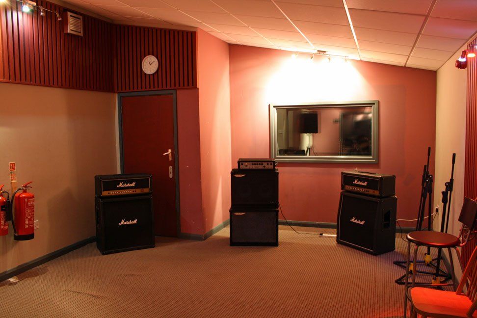 A room with a lot of speakers and a mirror