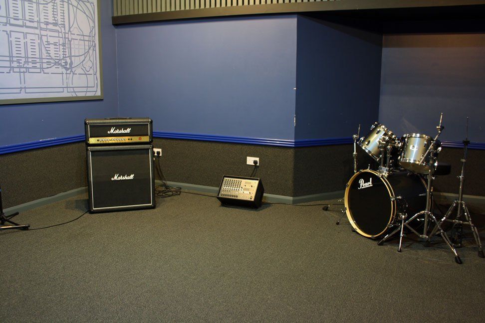A room with a drum set and a marshall amplifier