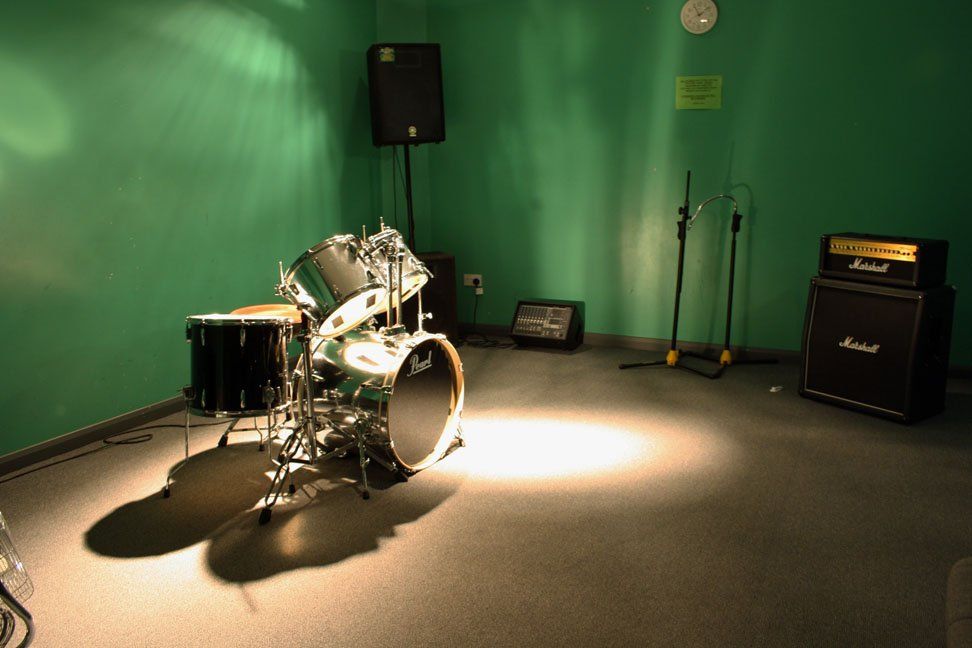A drum set in a room with a marshall amplifier