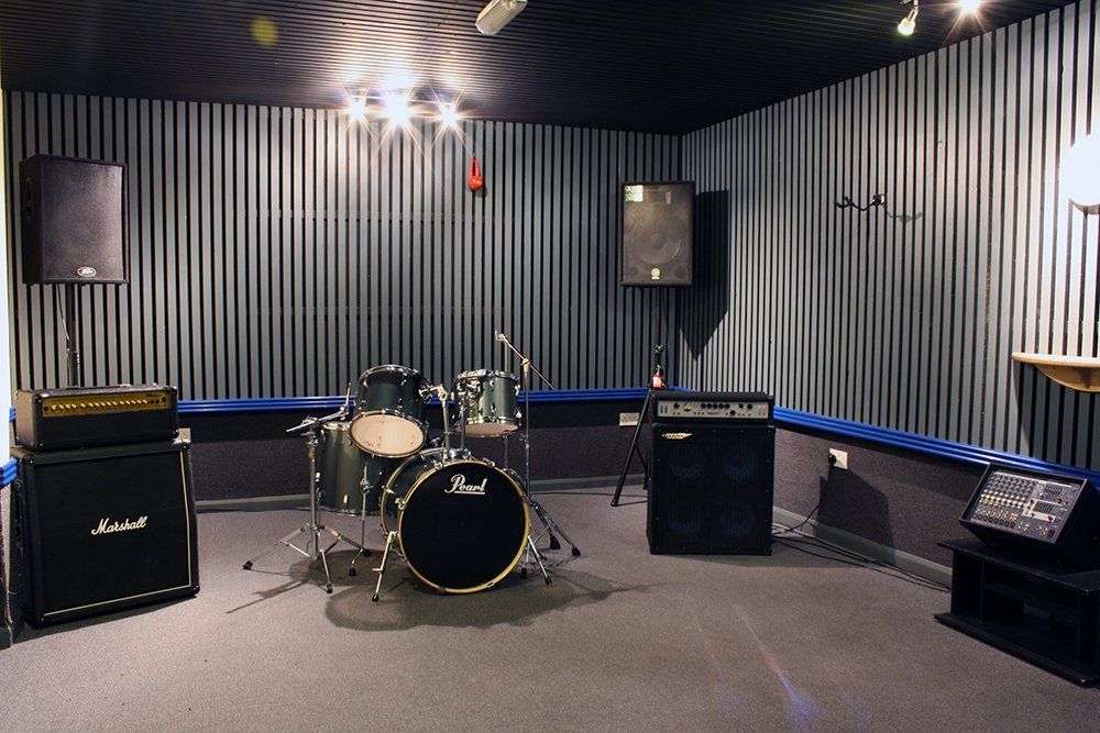 A drum set in a room with a marshall amplifier