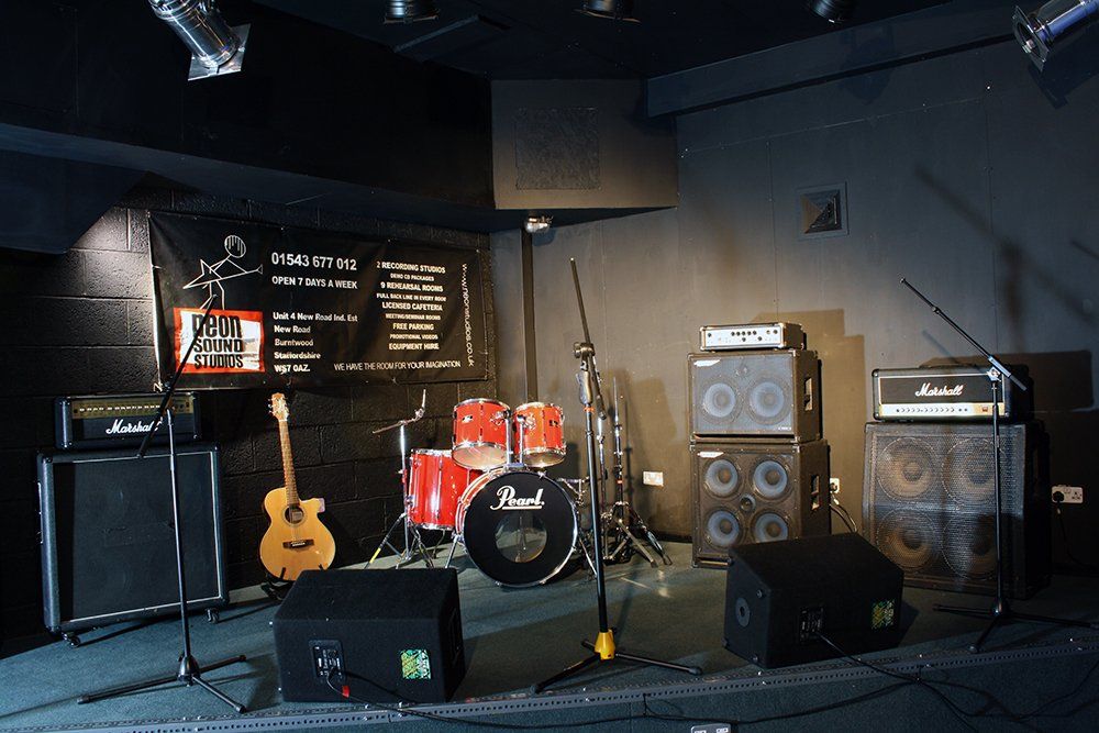 An empty stage with a drum set and a guitar