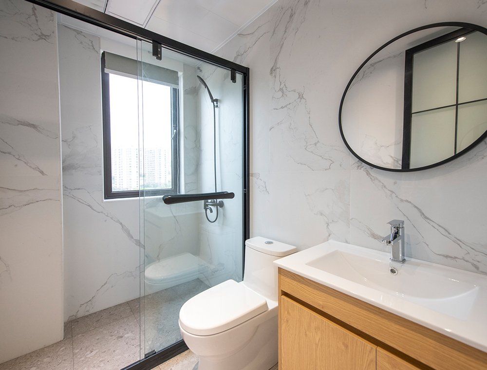 A bathroom with a toilet , sink , shower and mirror.