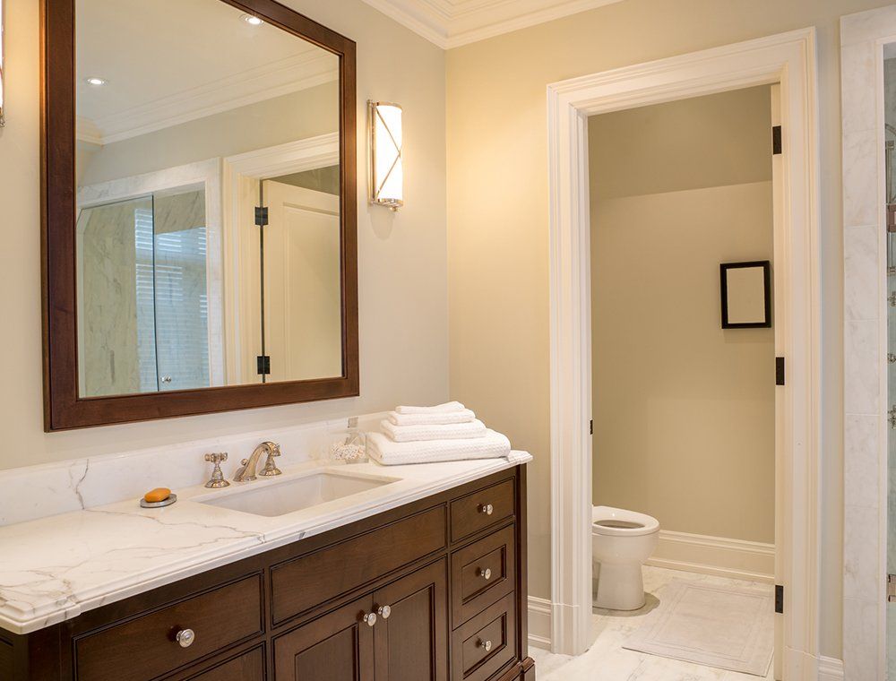 A bathroom with a sink , mirror and toilet.