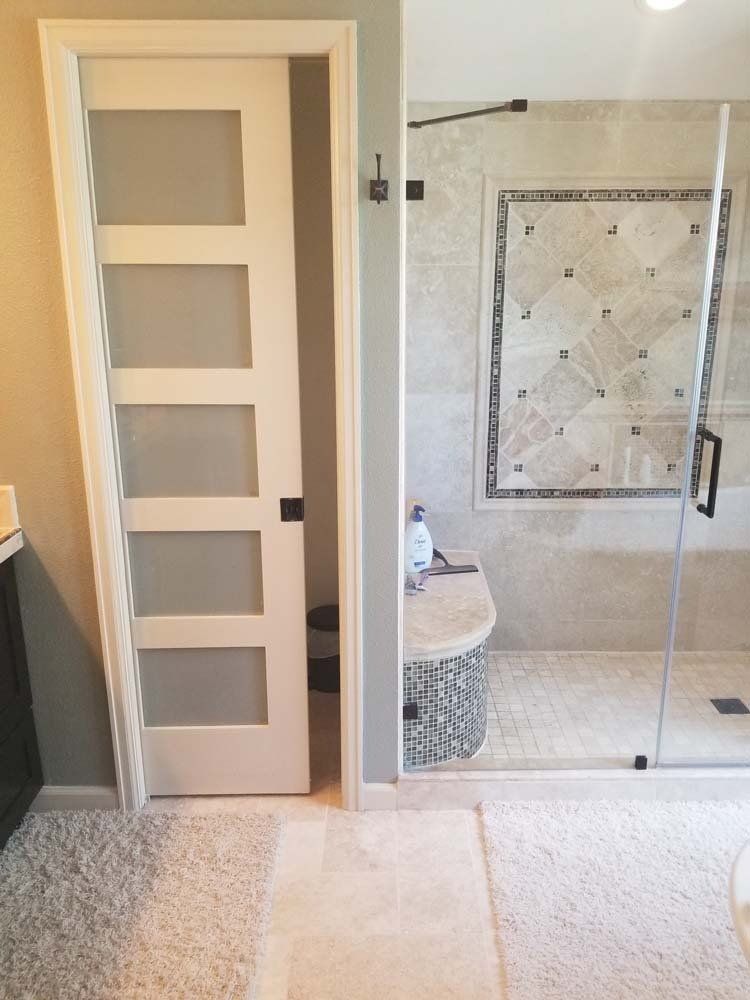 A bathroom with a sliding glass door and a walk in shower.