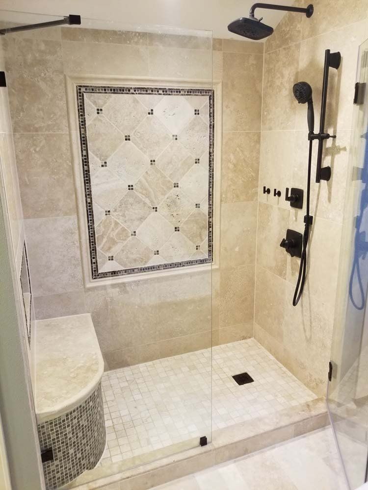 A bathroom with a walk in shower and a window.