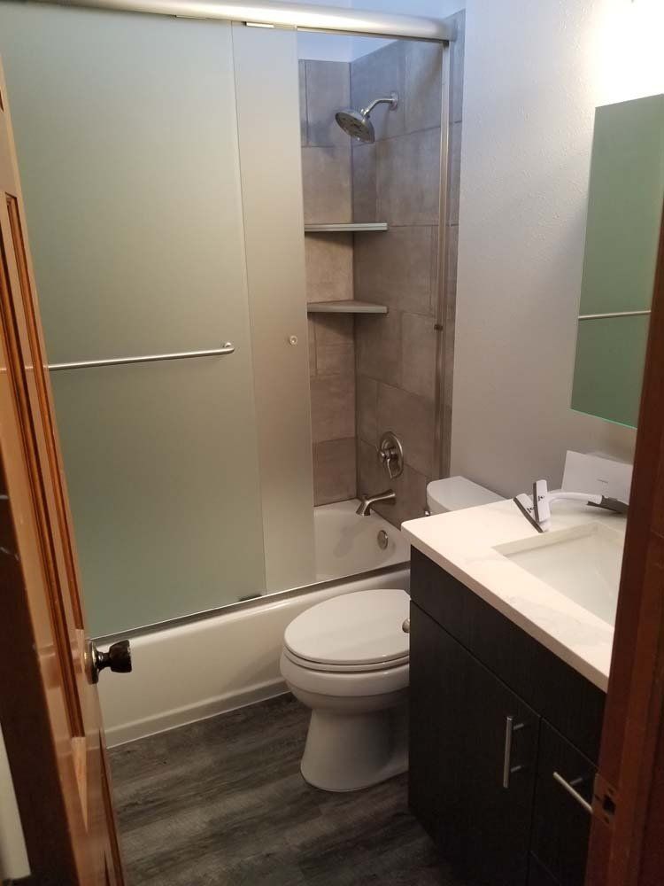 A bathroom with a toilet , sink , and shower.