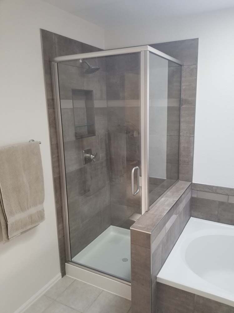 A bathroom with a walk in shower and a bathtub.