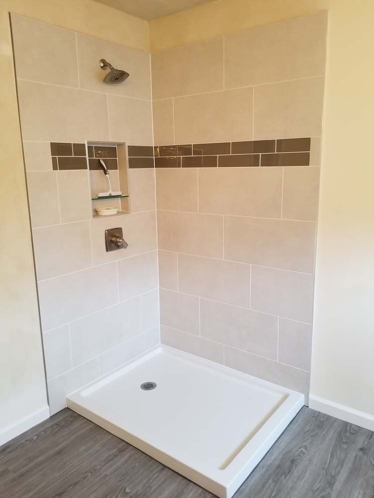 A bathroom with a walk in shower and a shower head.