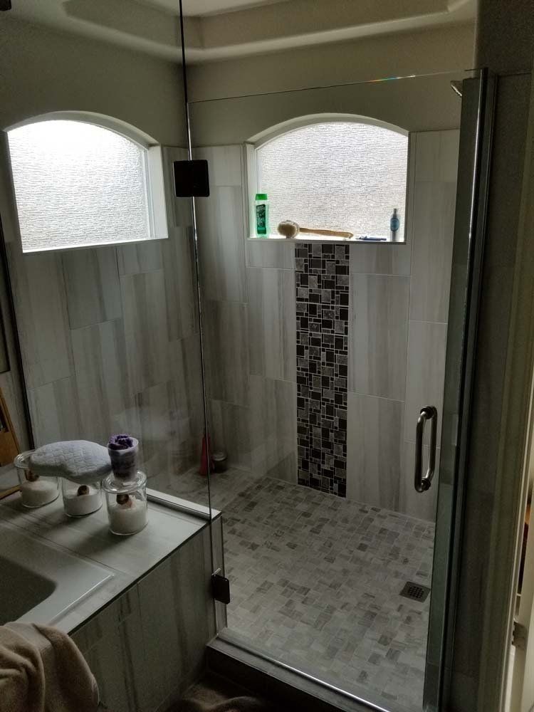 A bathroom with a walk in shower and a sink.