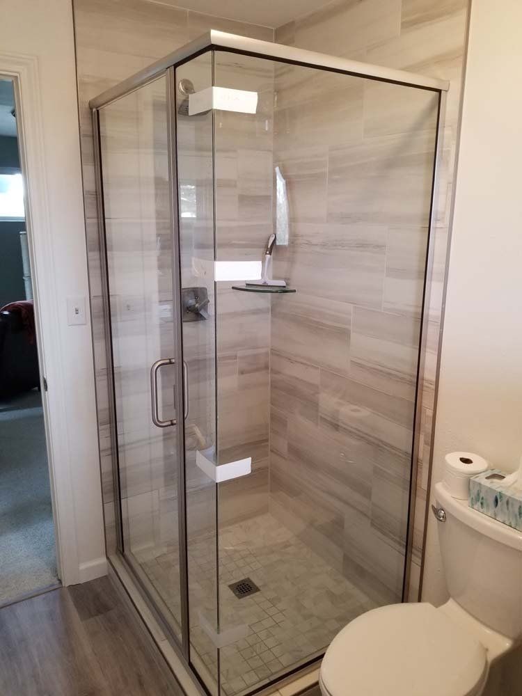 A bathroom with a walk in shower and a toilet.