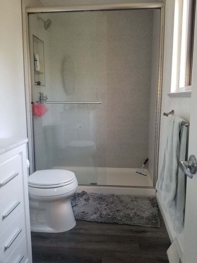A bathroom with a toilet , sink , and shower.