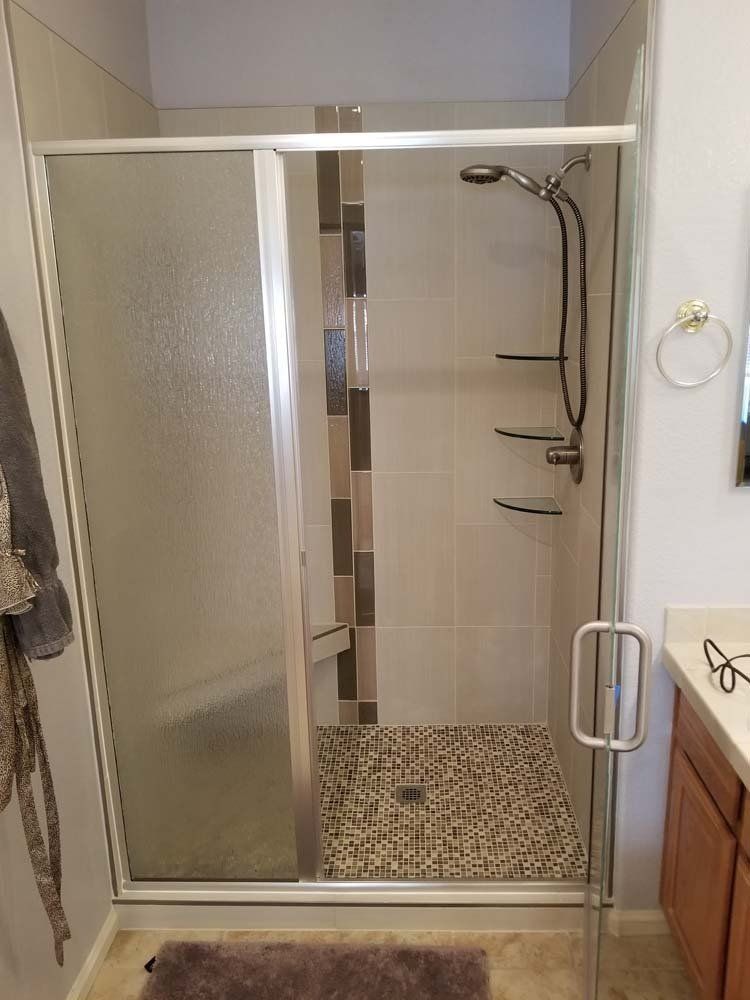 A bathroom with a walk in shower and a sink.