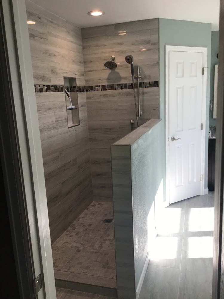 A bathroom with a walk in shower and a door.