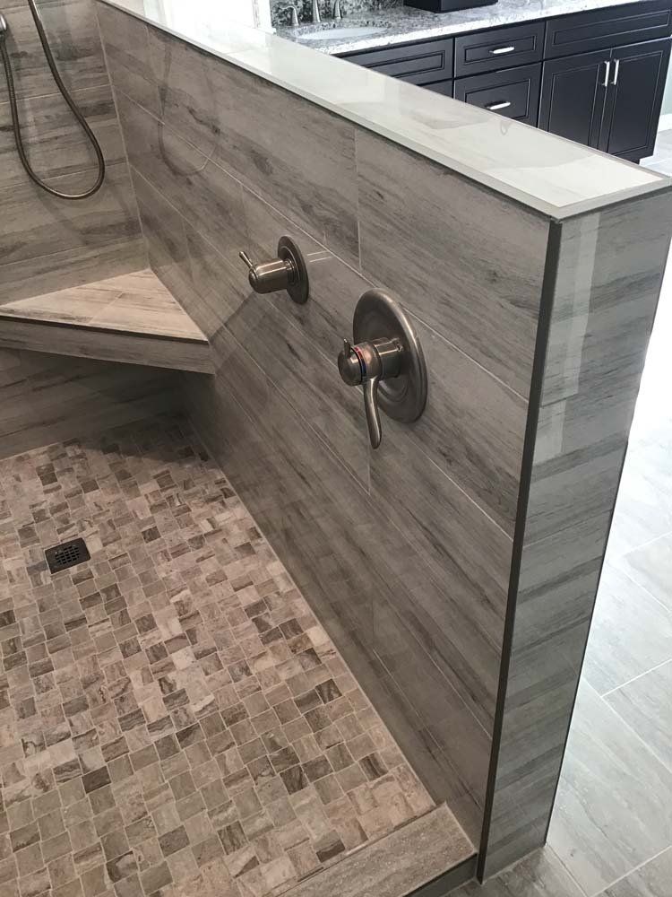 A bathroom with a walk in shower and a wooden wall.