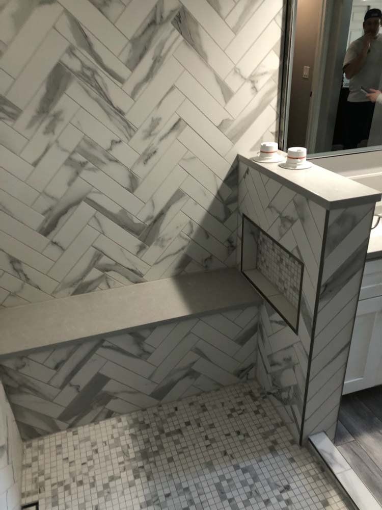 A bathroom with a shower , sink , and mirror.