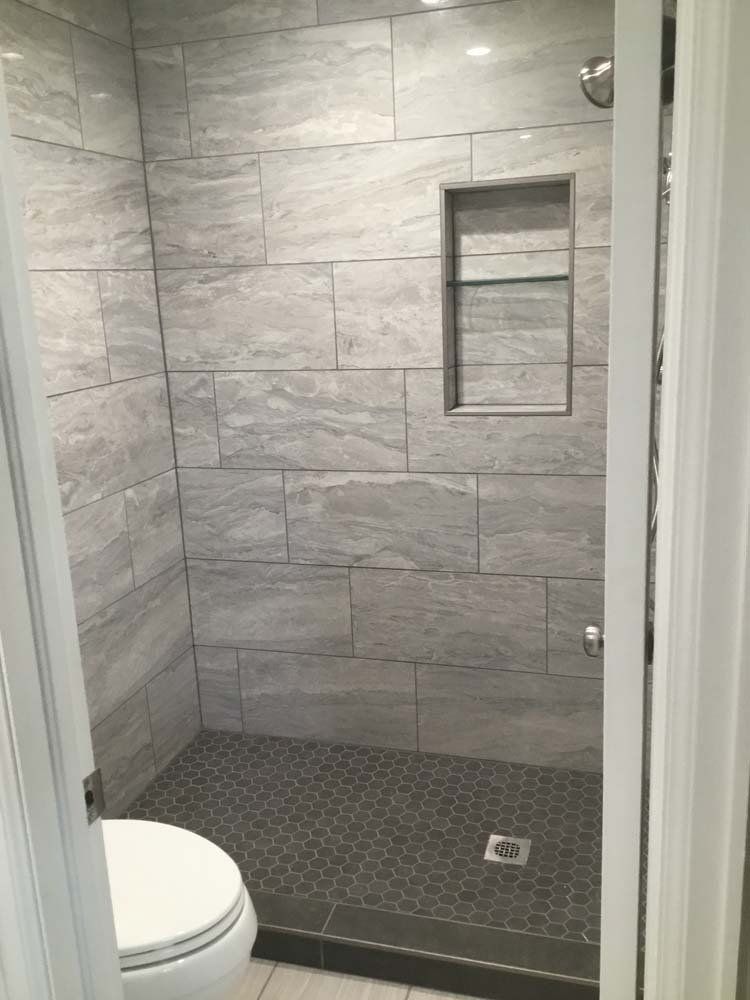 A bathroom with a toilet and a walk in shower.