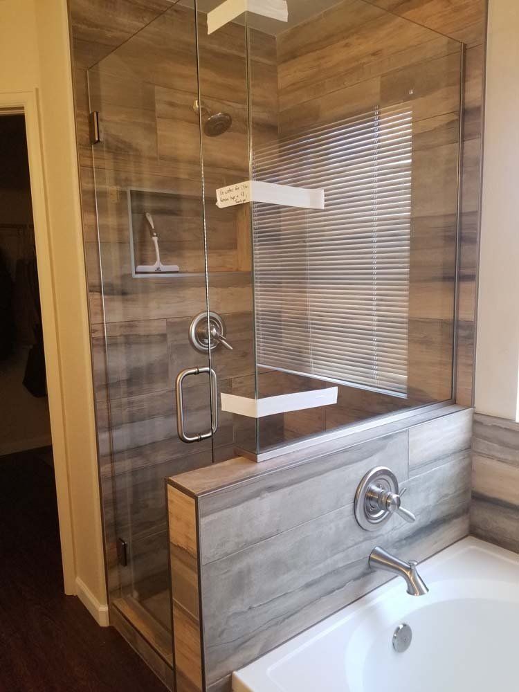 A bathroom with a walk in shower and a bathtub.