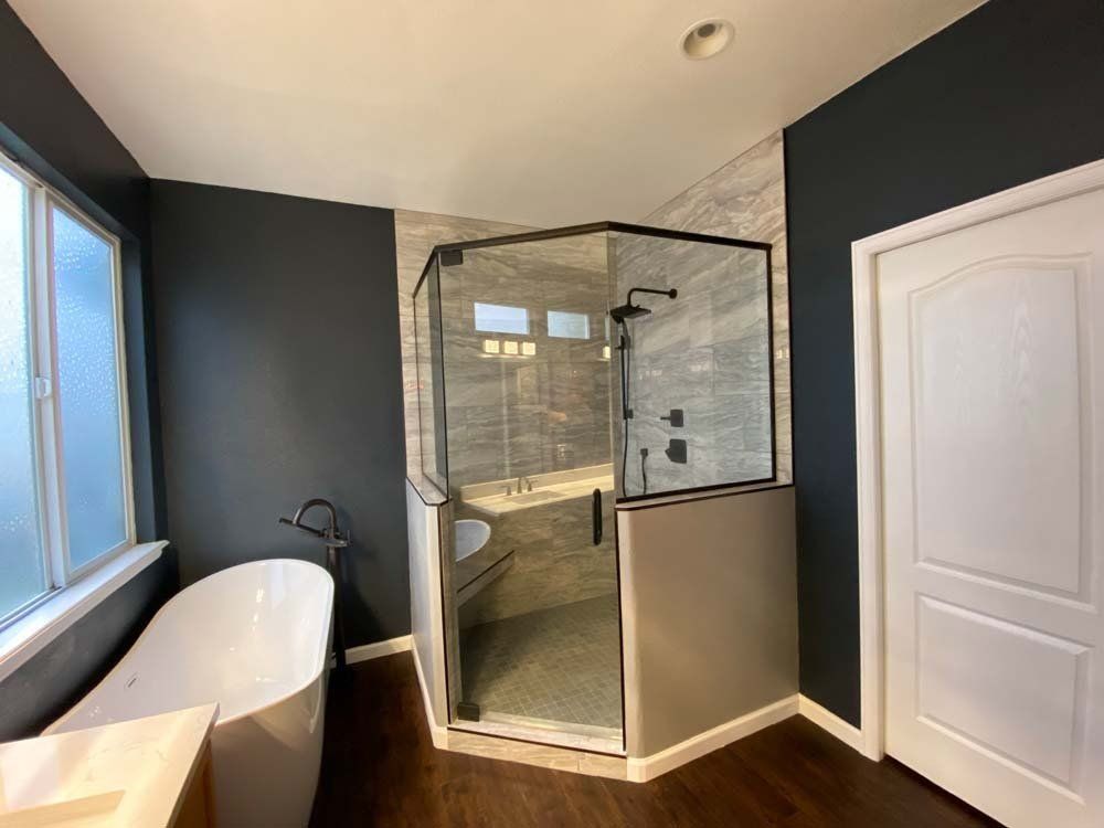 A bathroom with a bathtub and a walk in shower.