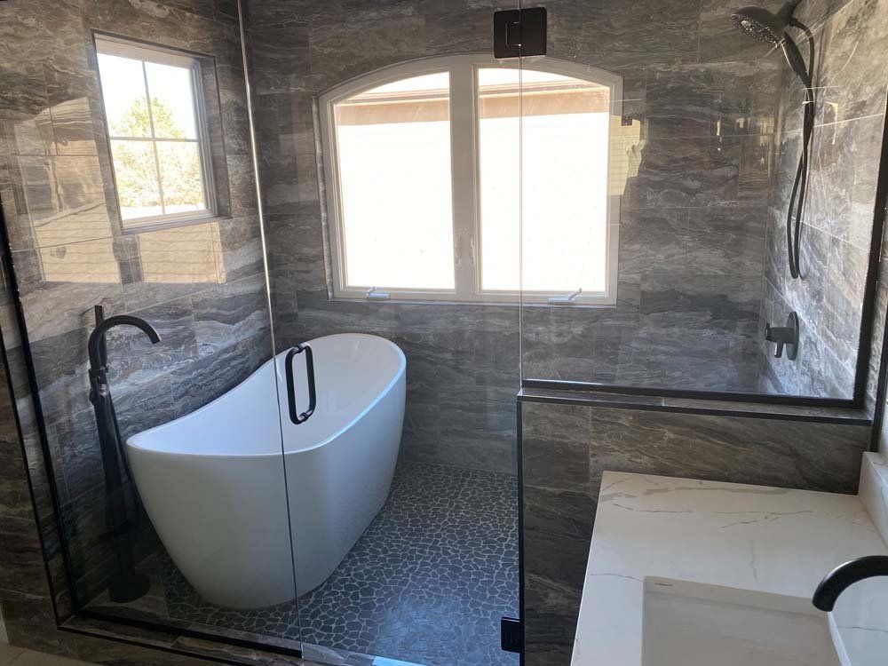 A bathroom with a tub and a shower with a glass door.