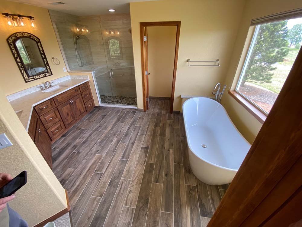 A bathroom with a tub , sink , mirror and walk in shower.