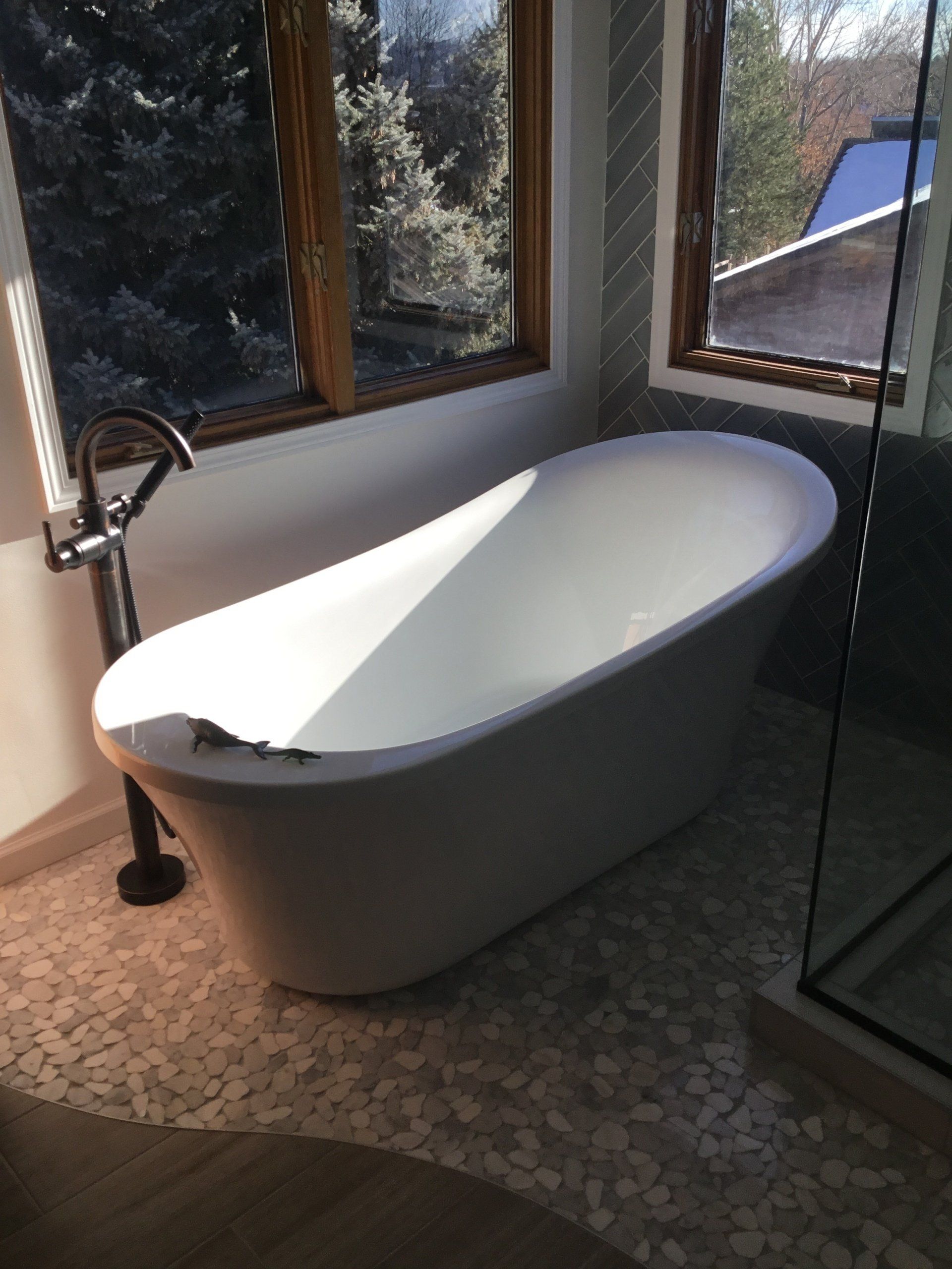 A bathtub is sitting in a bathroom next to a window.