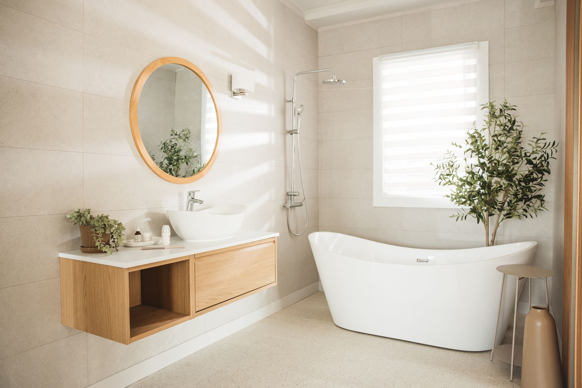 A bathroom with a tub , sink , mirror and window.