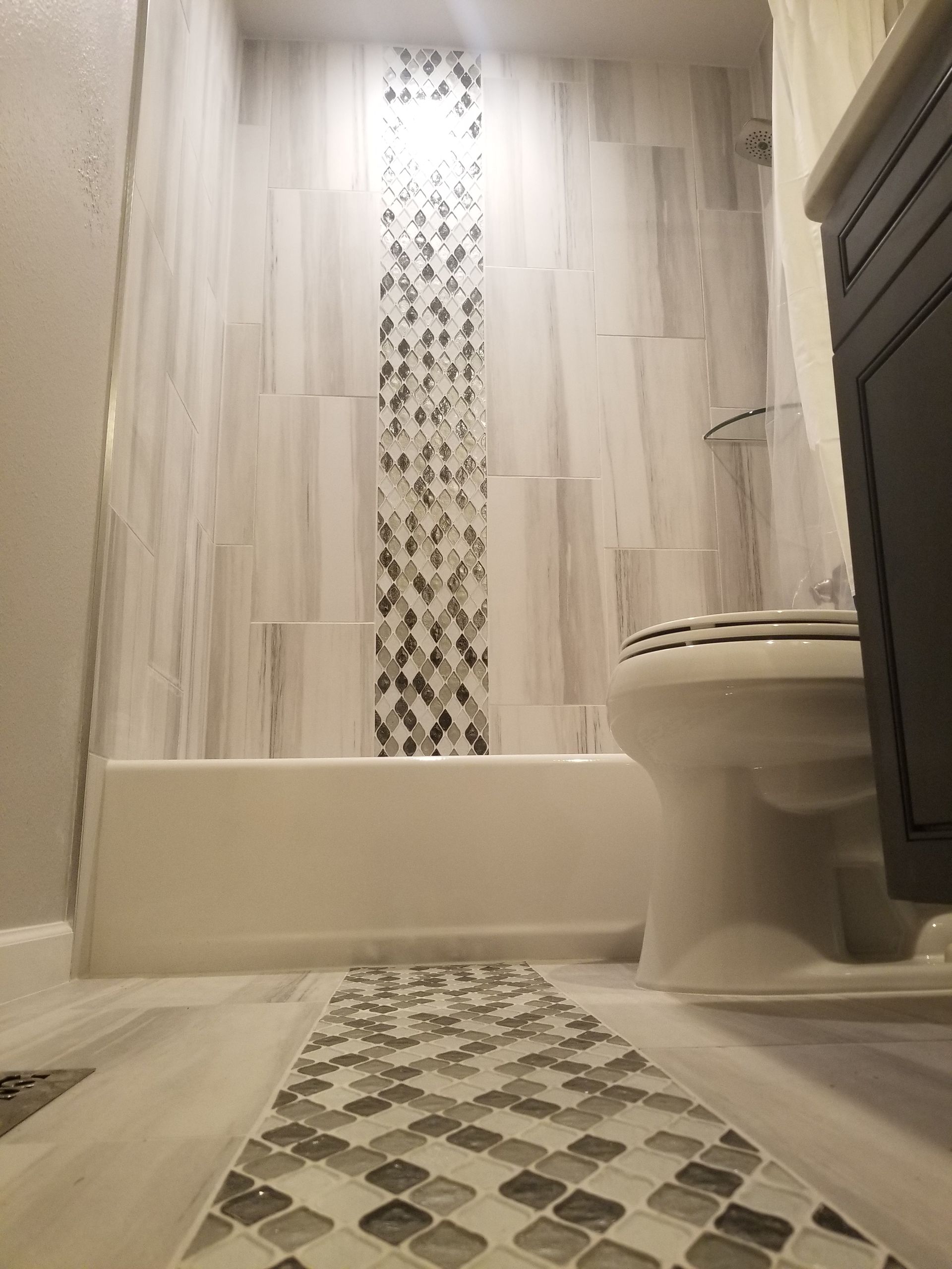 A bathroom with a toilet , bathtub and shower.