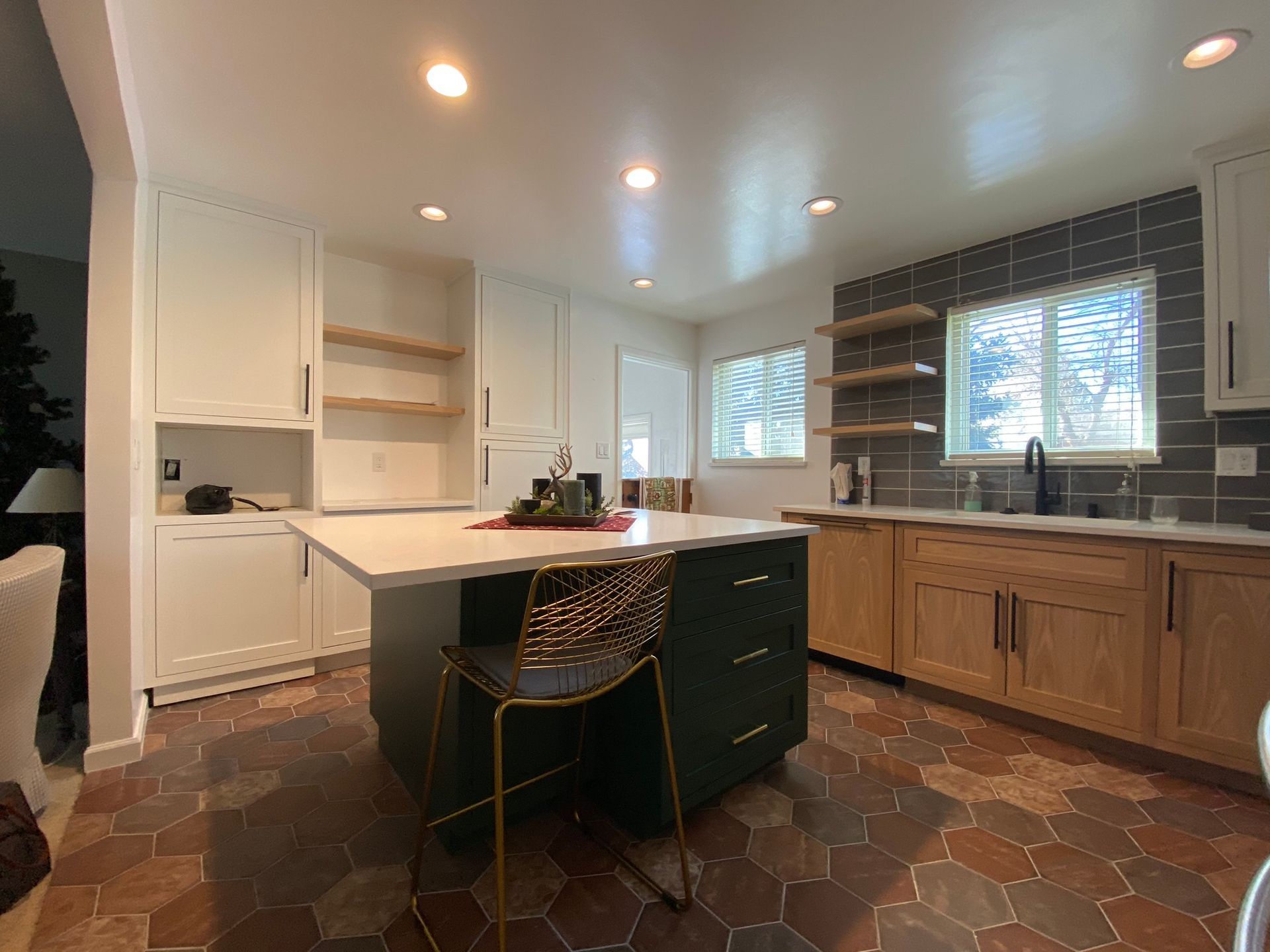 A kitchen with a large island and a chair in it.