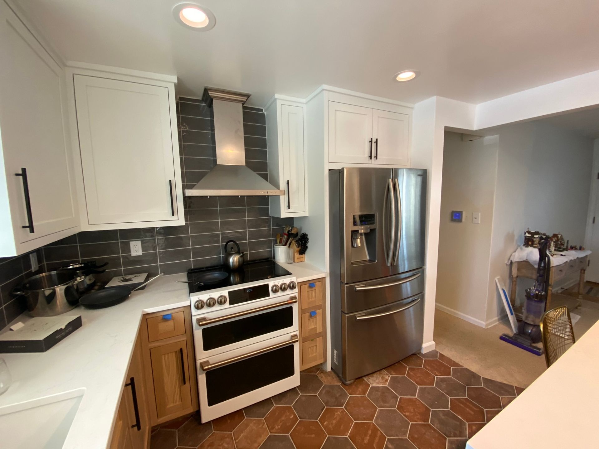 A kitchen with stainless steel appliances and white cabinets.