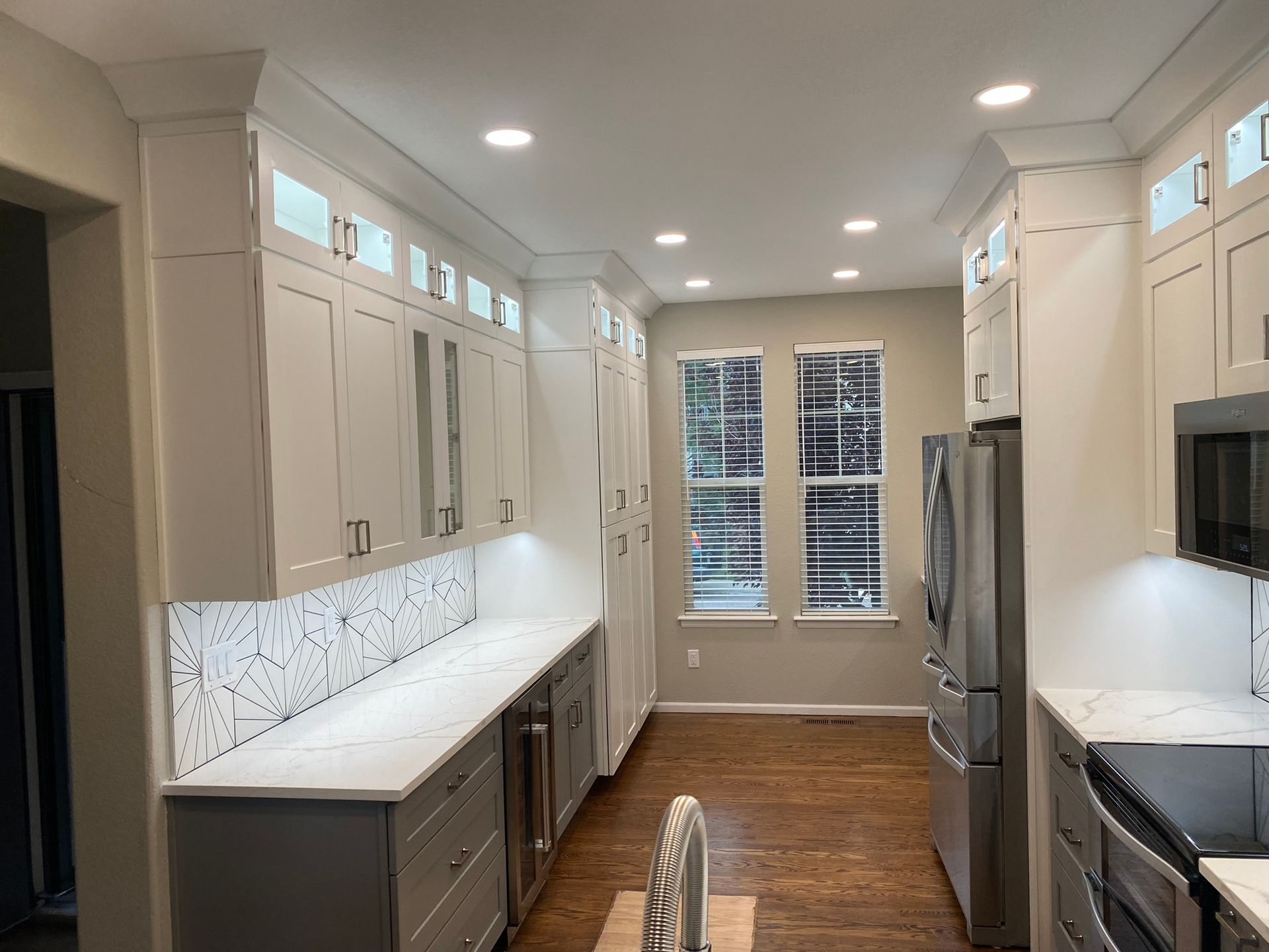A kitchen with white cabinets and stainless steel appliances.